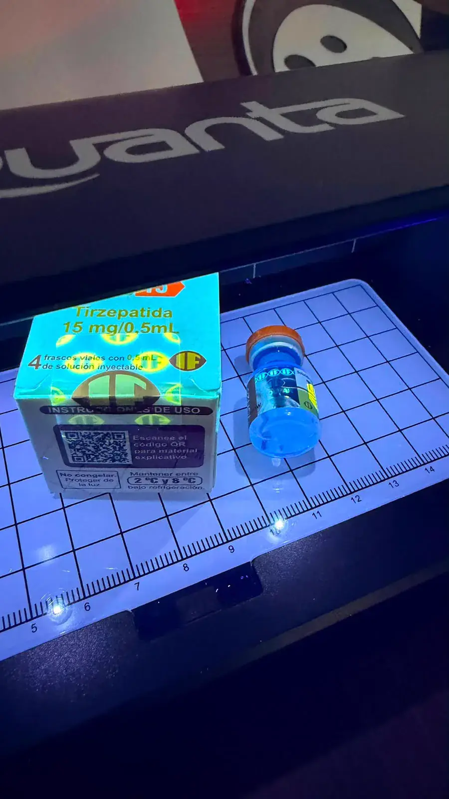 Caixa e frasco de TG 15 tirzepatida sob luz ultravioleta durante conferência de autenticidade
